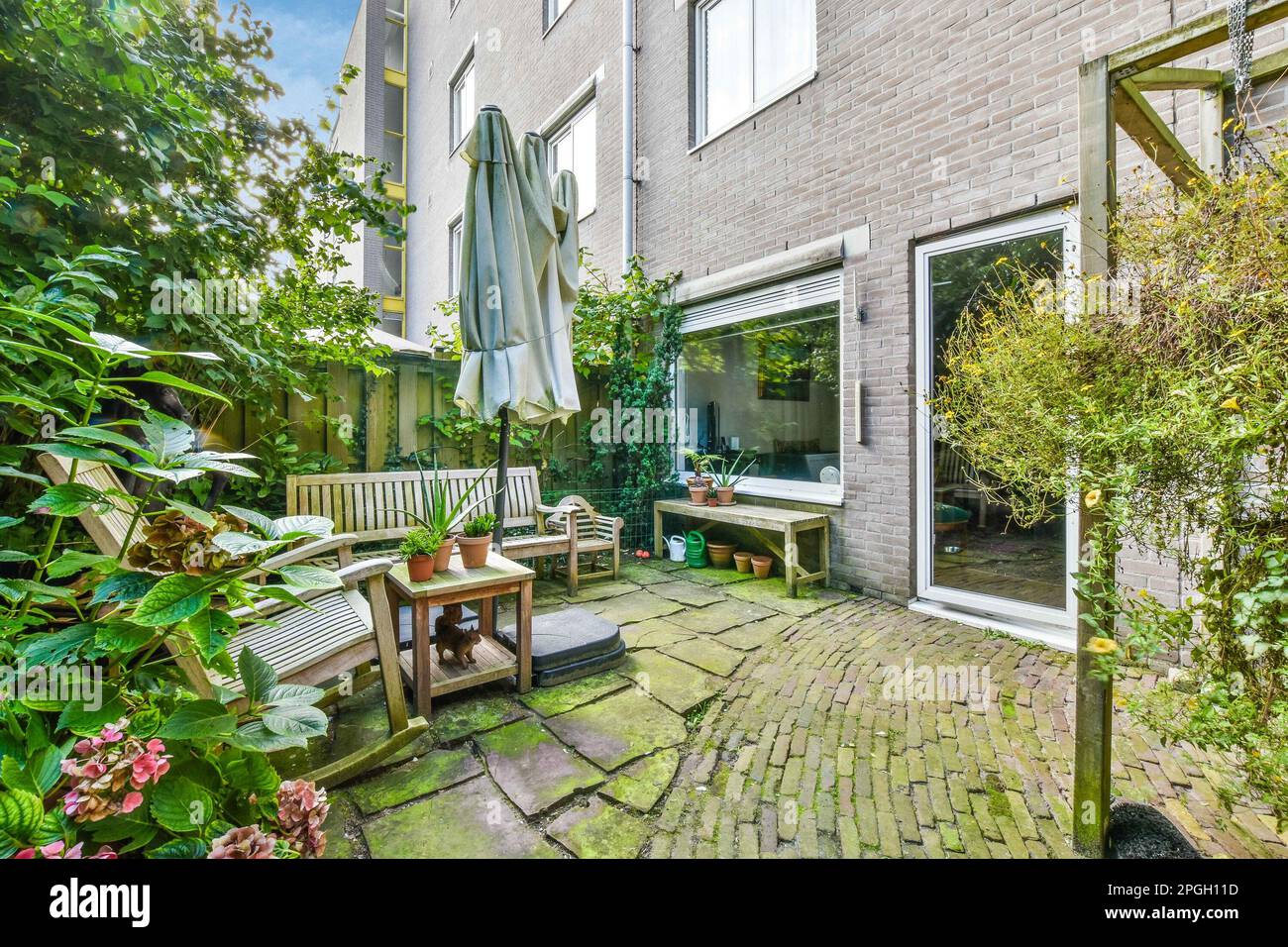 a patio with benches and plants in the back yard, looking out onto the ...