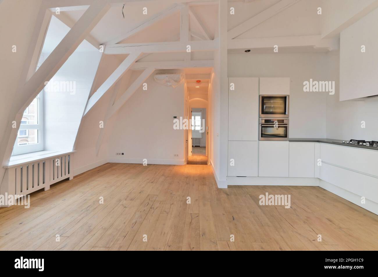 an empty kitchen with wood flooring and white walls in a room that has ...