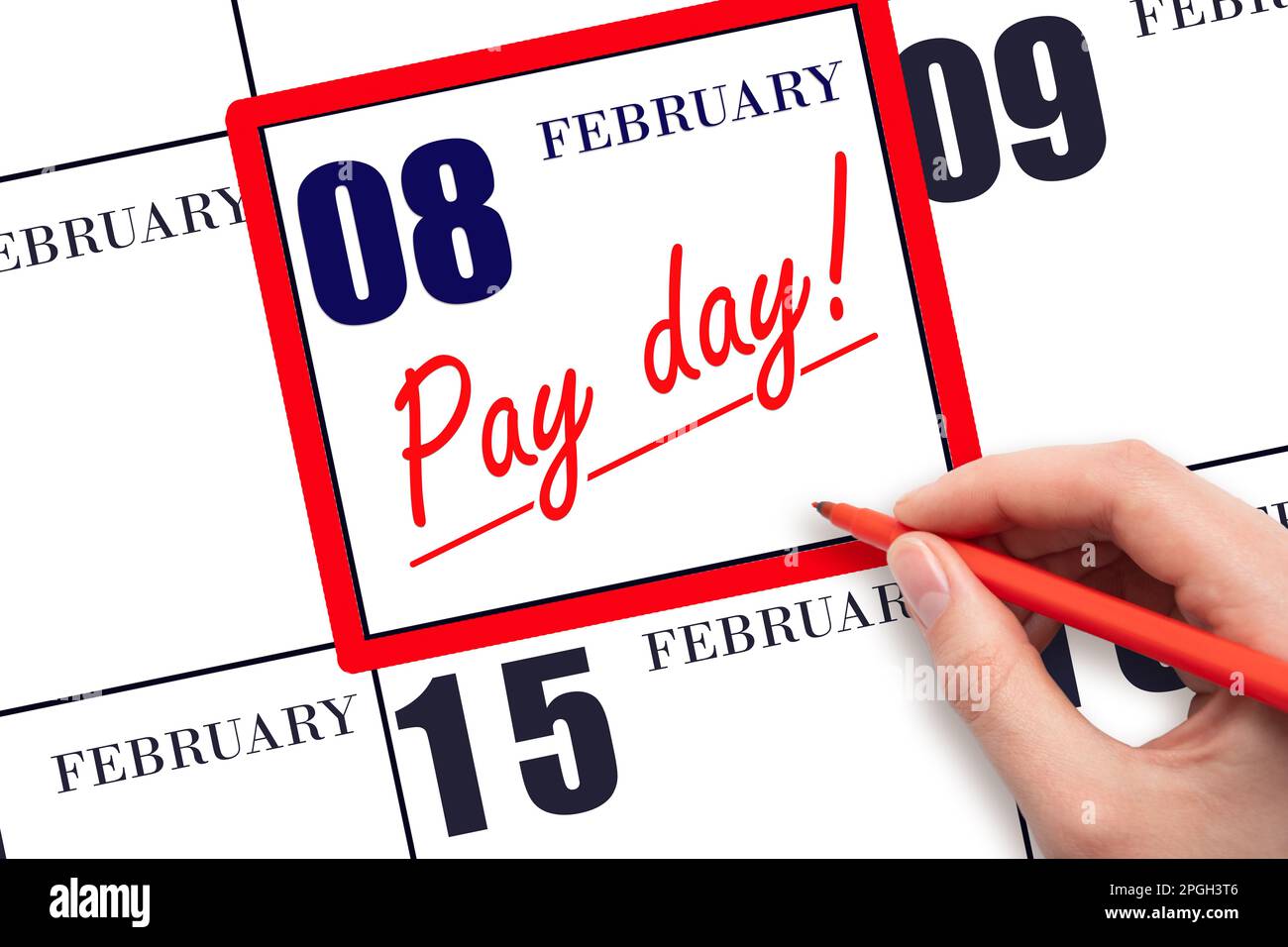 8th day of February. Hand writing text PAY DATE on calendar date February 8 and underline it. Payment due date. Reminder concept of payment. Winter mo Stock Photo