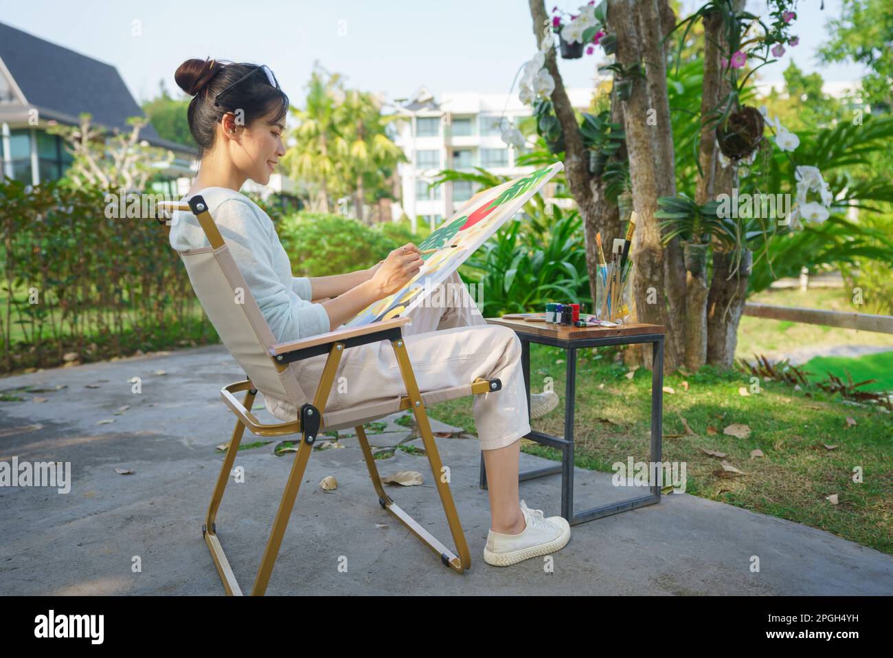 Artist concept, Female artist sitting in the park and painting picture ...