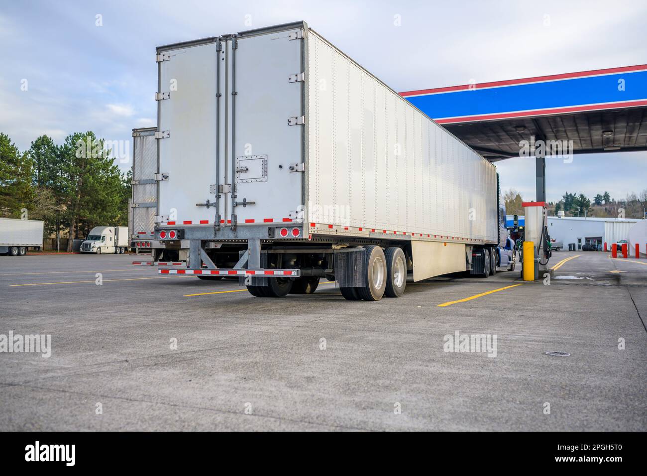 Industrial big rigs semi truck tractors with semi trailers standing ...