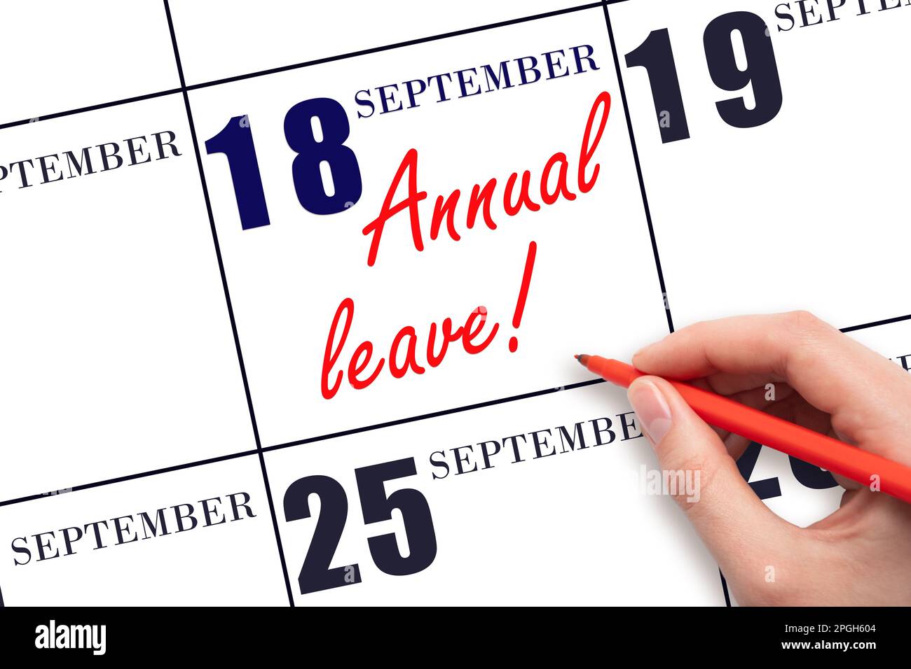 18th day of September. Hand writing the text ANNUAL LEAVE and drawing the sun on the calendar date September 18. Save the date. Time for the holidays. Stock Photo