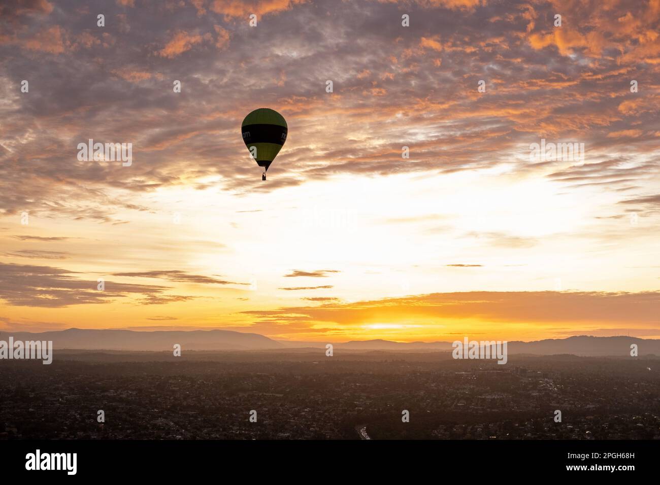 Hot air balloon against a colorful sky and clouds at sunrise in Melbourne, Victoria, Australia Stock Photo