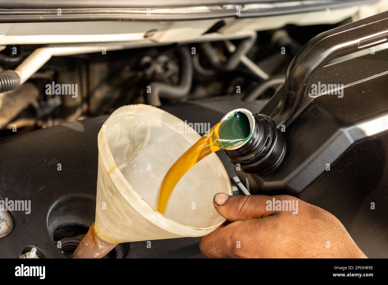 Pouring new engine oil into the vehicle engine Stock Photo Alamy