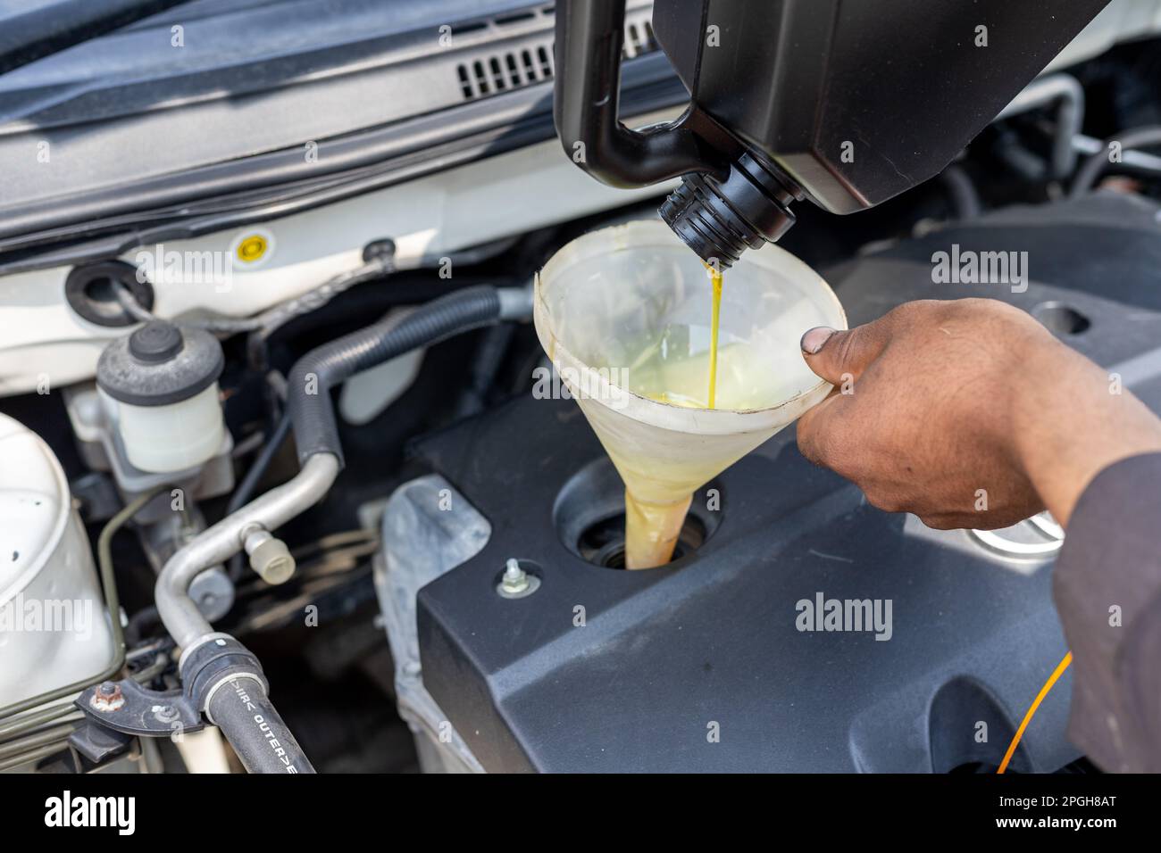 Pouring motor oil to engine with the help of a funnel Stock Photo Alamy