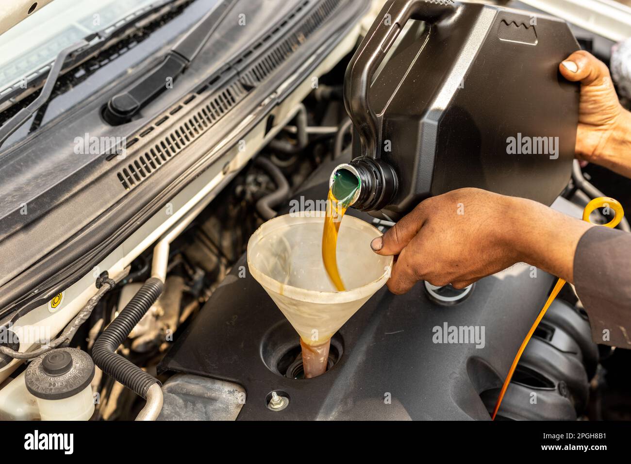 Mechanic pouring motor oil into the car engine Stock Photo Alamy