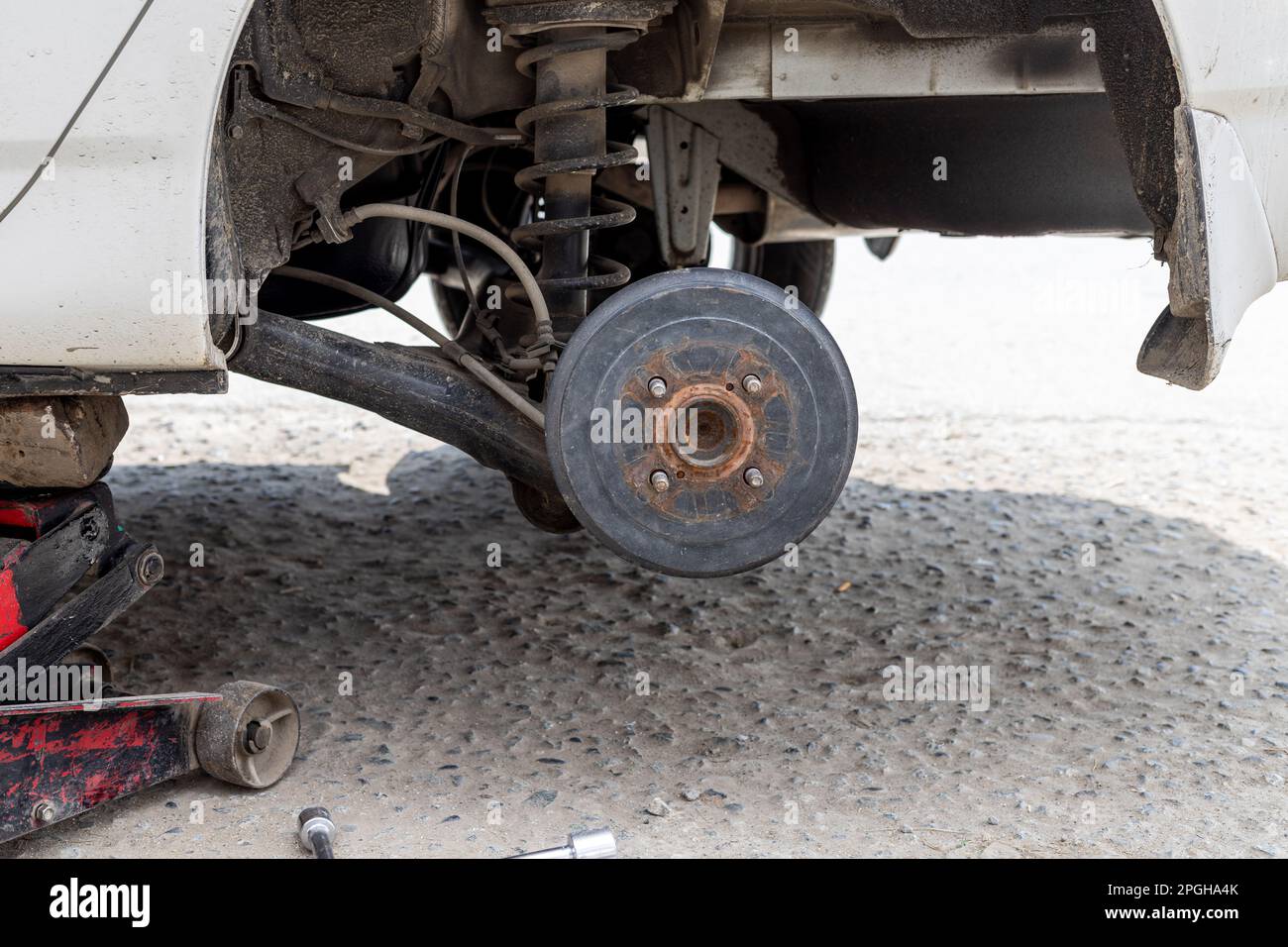 Rear wheel removed, and car is been lifted by hydraulic jack for repair