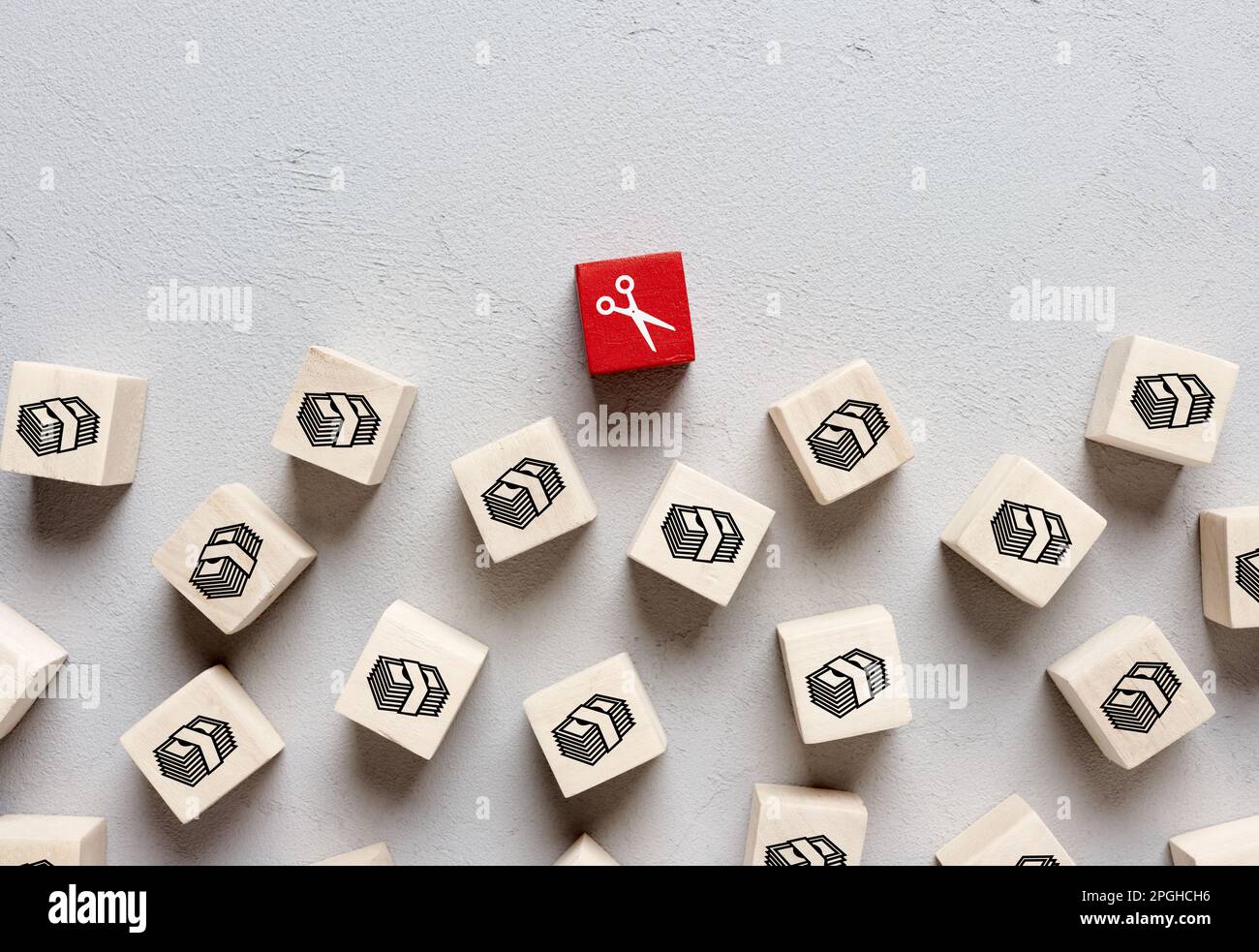 Budget cut concept. Income reduction, economic crisis, business loan or debt. Scissors and money icons on wooden cubes. Stock Photo