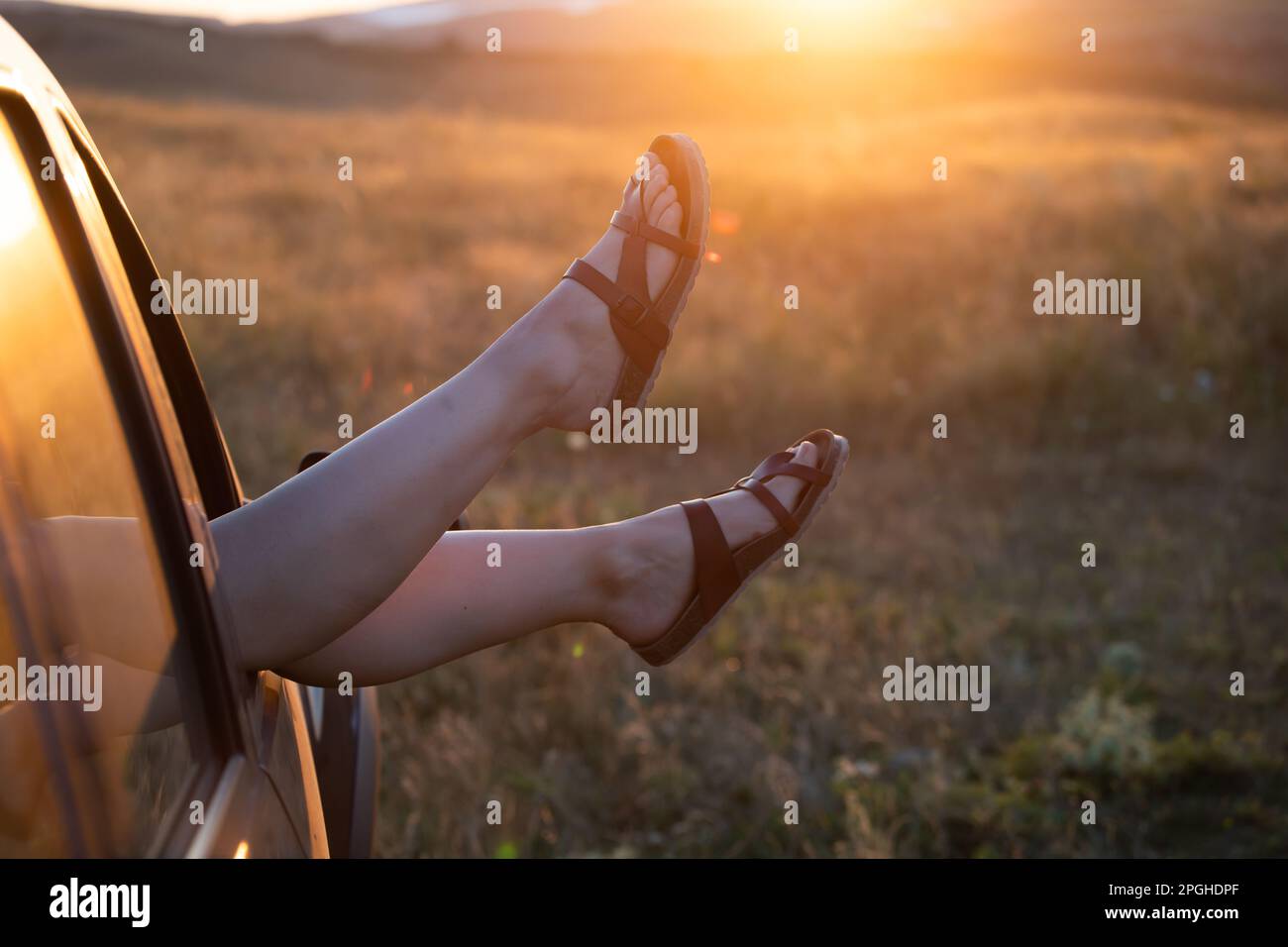 Woman's legs out of car windows.Freedom, travel and vacation road trip concept lifestyle image. Stock Photo