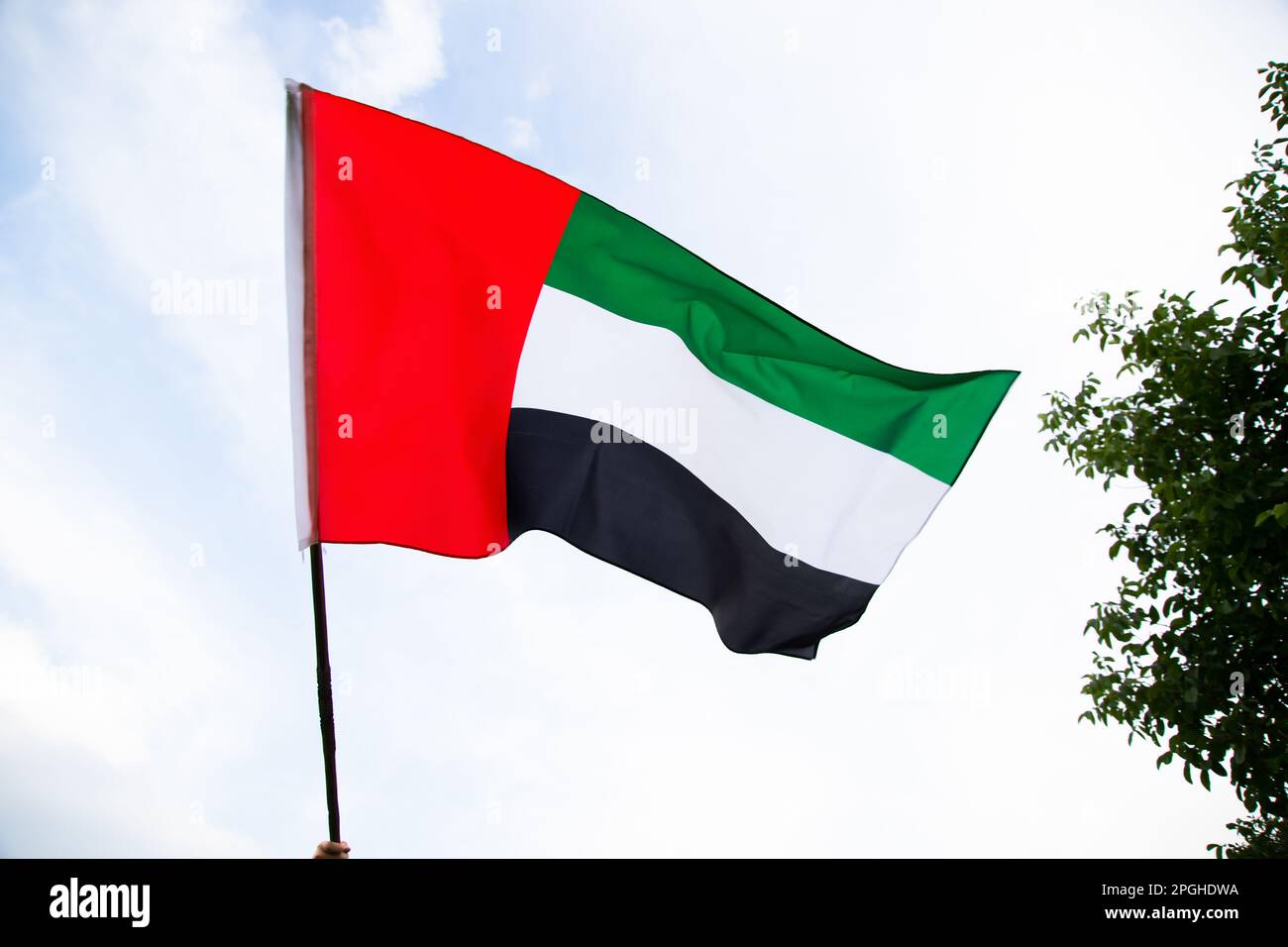 United Arab Emirates flag flying against clean and tranquil sky. UAE celebrates it's national day on 2nd December every year. Stock Photo