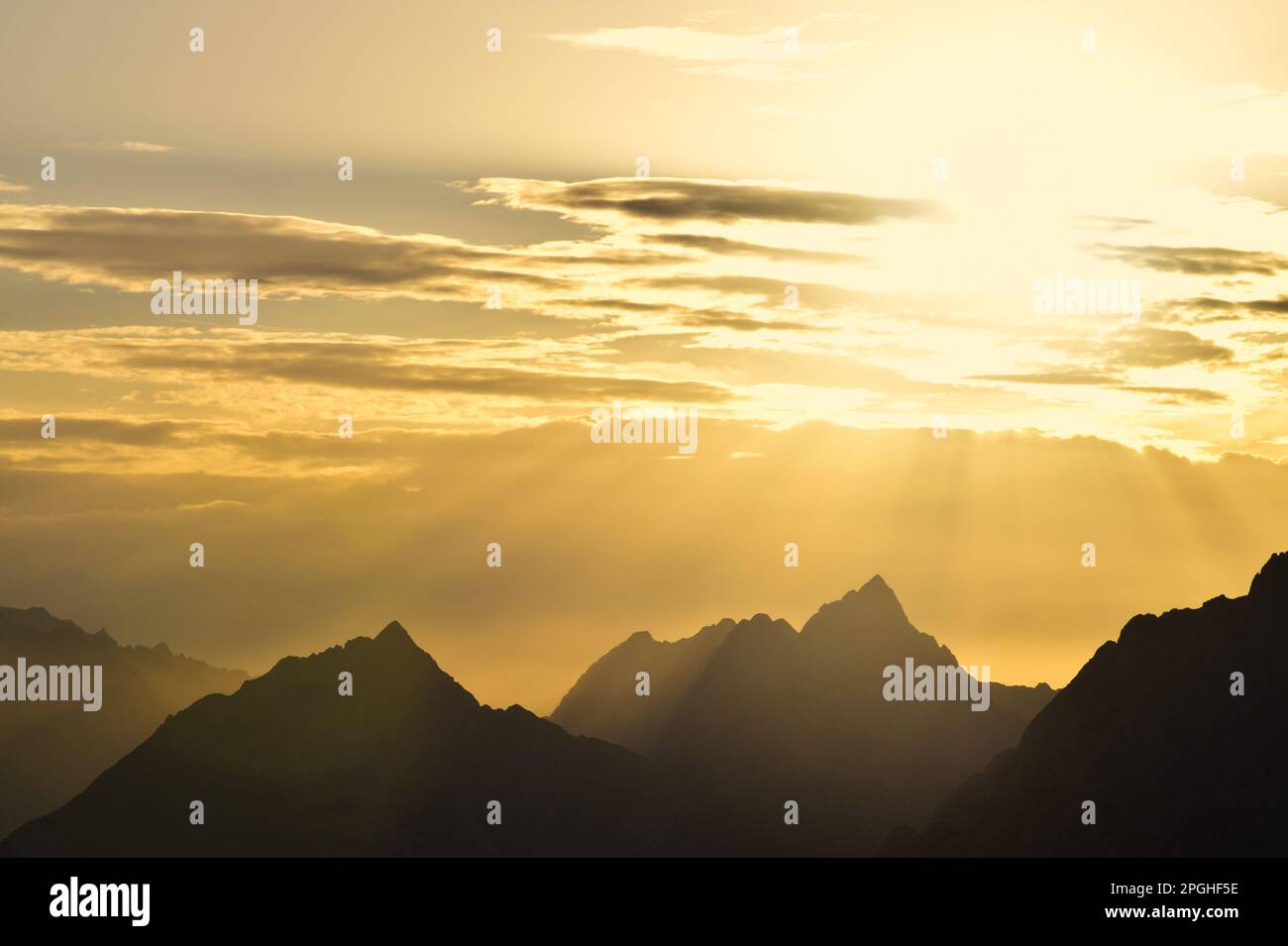 The silhouetted mountain peaks against a stunning sunset sky Stock ...