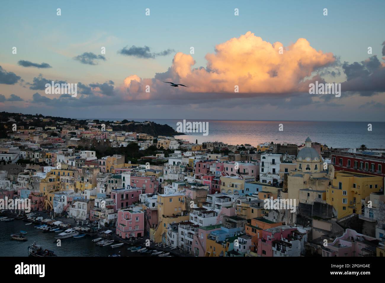 View of the Port of Corricella with lots of colorful houses in the sunset in Procida Island, Italy. Stock Photo
