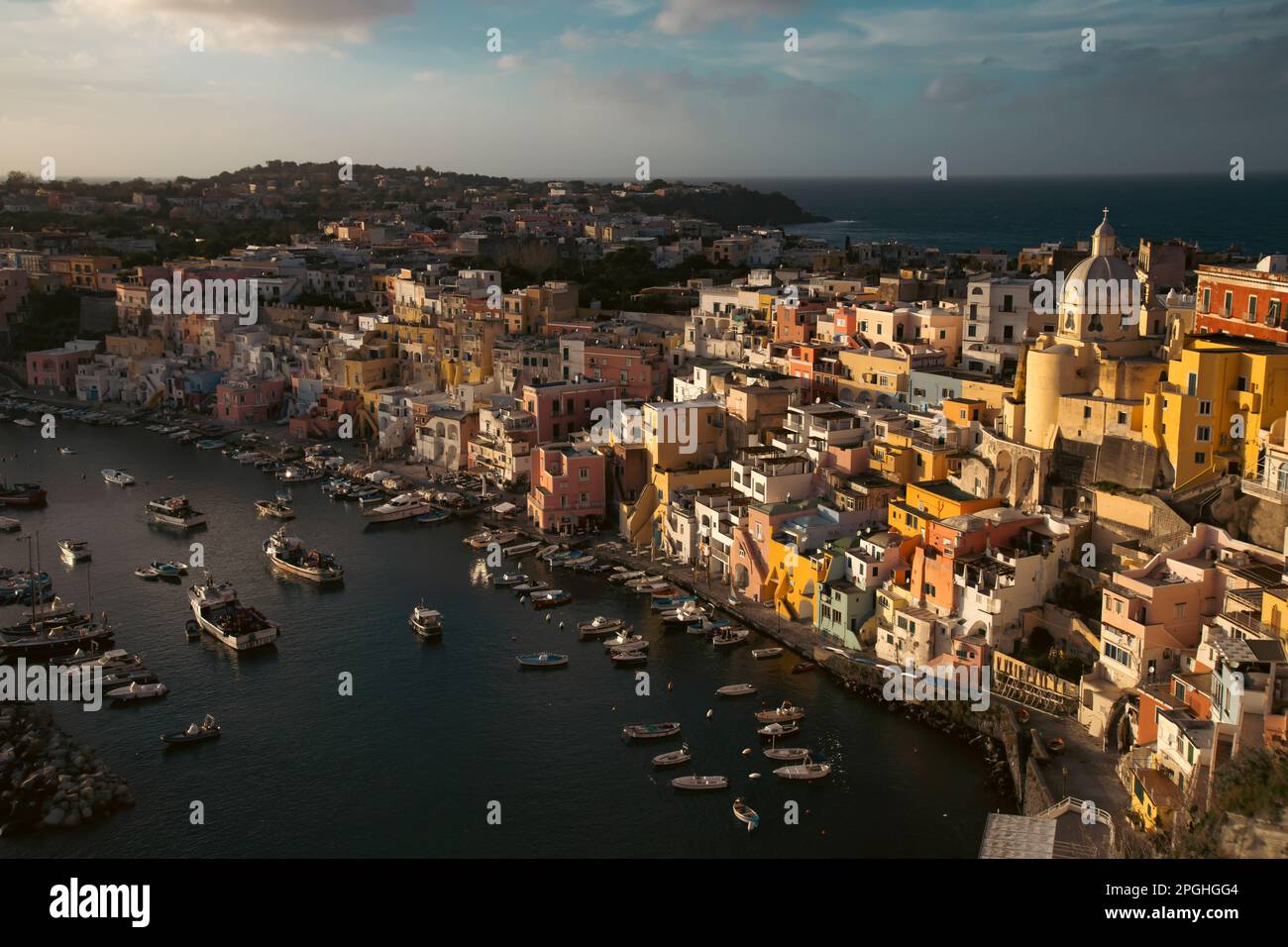 View of the Port of Corricella with lots of colorful houses in the sunset, Procida Island, Italy. Stock Photo