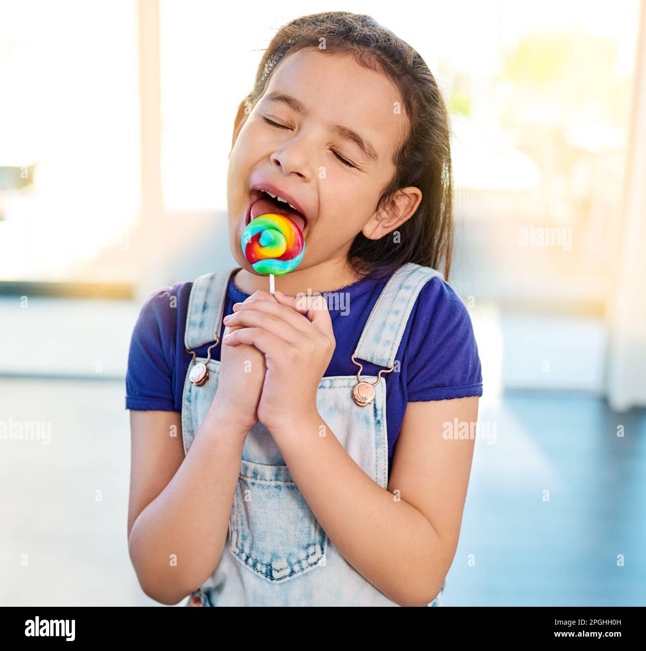 Nothing tastes better than candy. an adorable little girl enjoying her lollipop sucker at home. Stock Photo