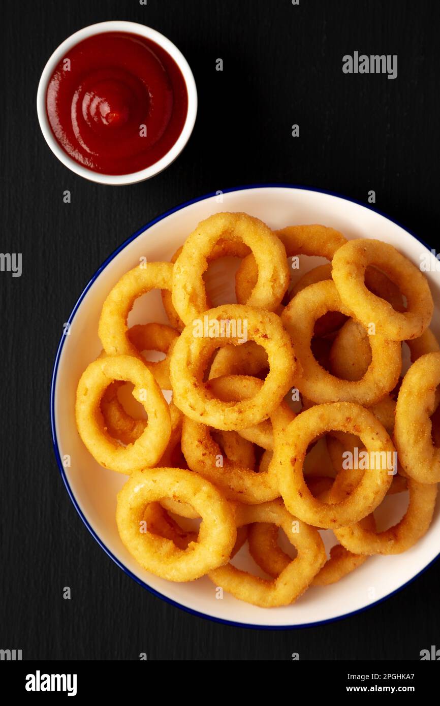 Homemade Breaded Onion Rings with Ketchup on a Plate on a black