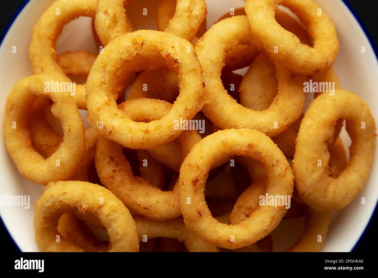 Homemade Breaded Onion Rings on a Plate on a black background, top view