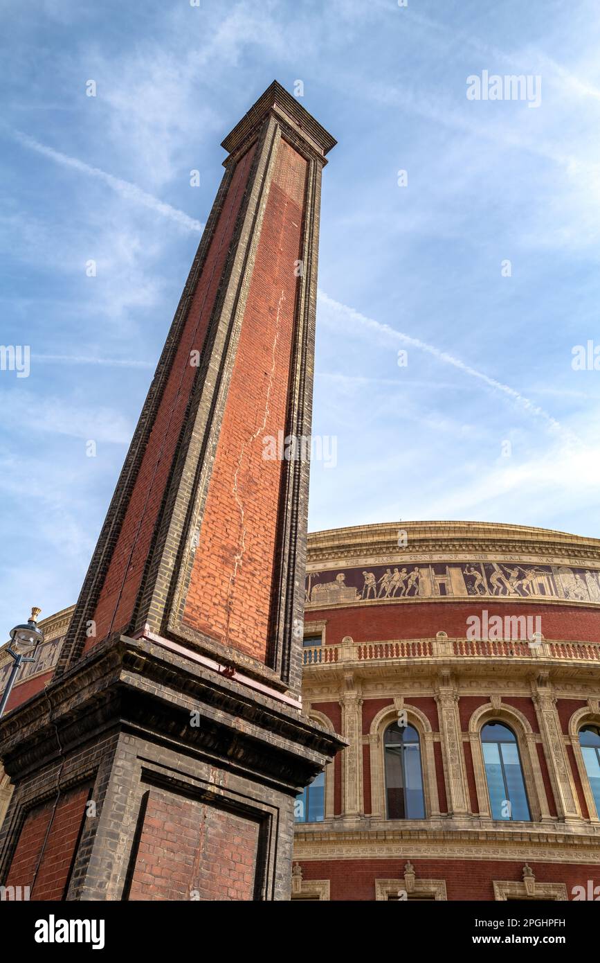 London, UK - 17 April 2022, the Royal Albert Hall chimney and hall in the background, against blue sky. Both building are Grade 1 listed and in trust Stock Photo