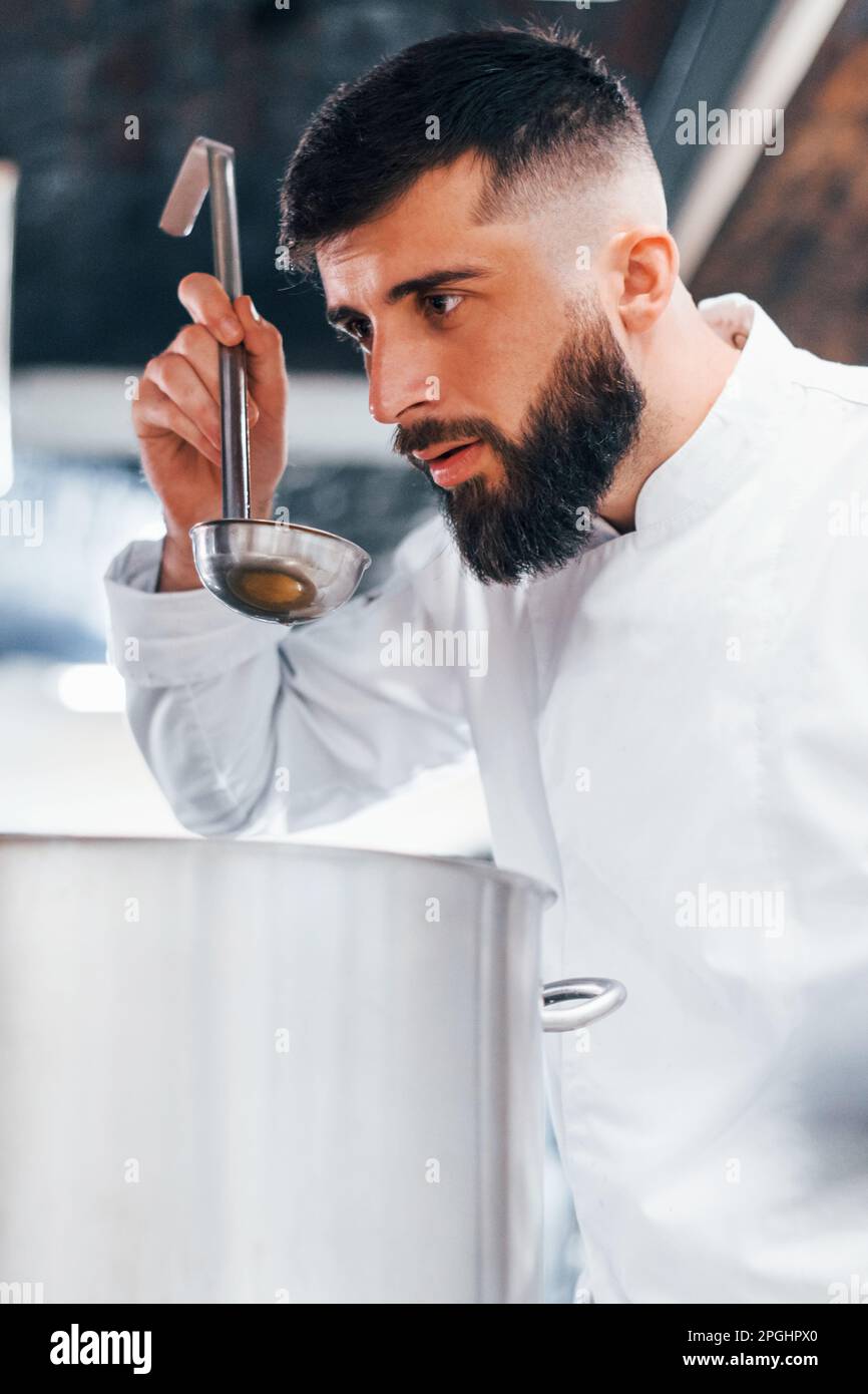 Making delicious product. Chef in white uniform cooking food at kitchen ...