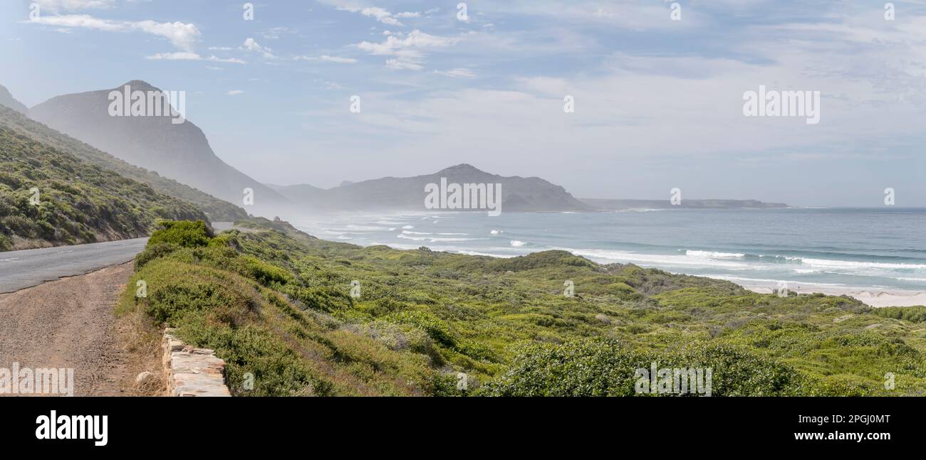 landscape with road on green shore of Atlantic Ocean  at Misty Cliffs, shot in  bright summer light with sea mist,  Cape Town, Western Cape, South Afr Stock Photo