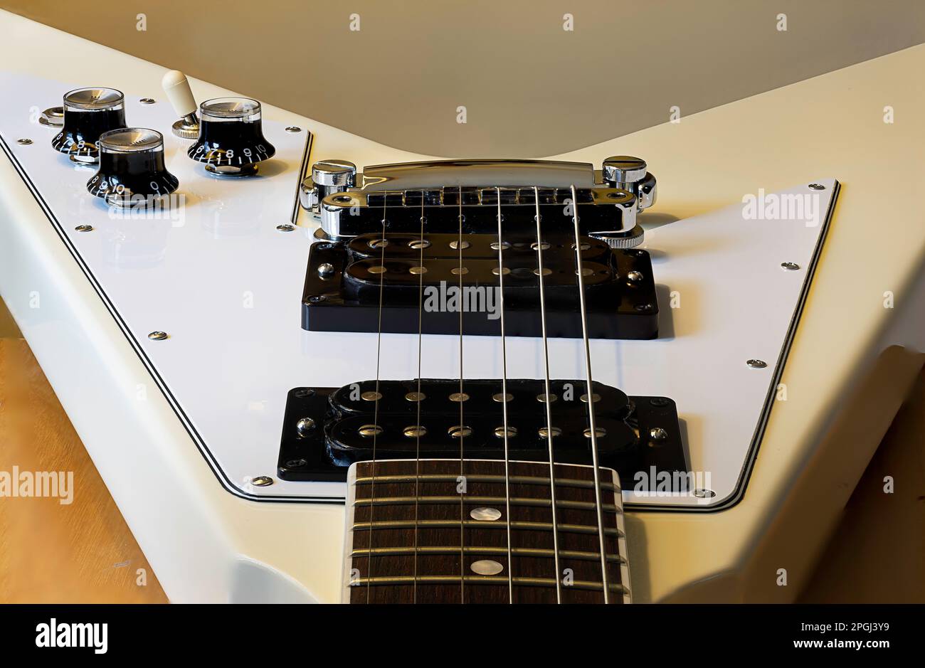 A closeup shot of frets and pickups on an electric guitar in a studio