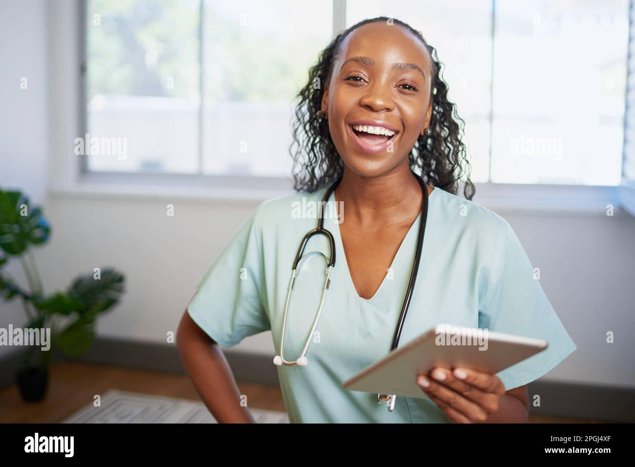 Portrait of a young Black female doctor, laughing with digital tablet Stock Photo