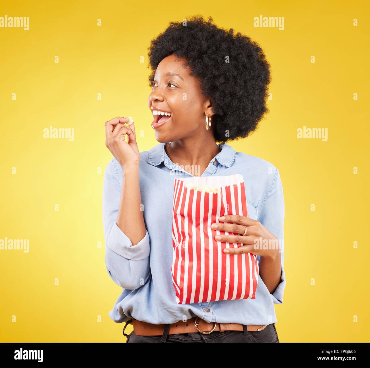 Happy, eating and popcorn with black woman in studio for movie, streaming service and cinema. Television, smile and theatre with female and snack Stock Photo