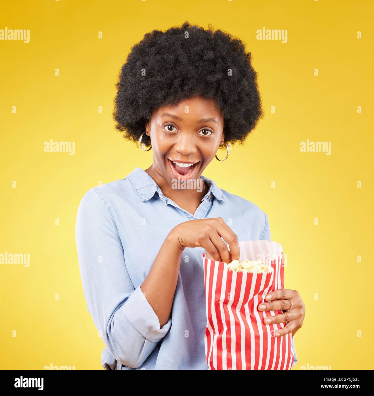 Surprise, wow and popcorn with black woman in studio for movie, streaming service and cinema. Happy, comedy and theatre with female and snack isolated Stock Photo