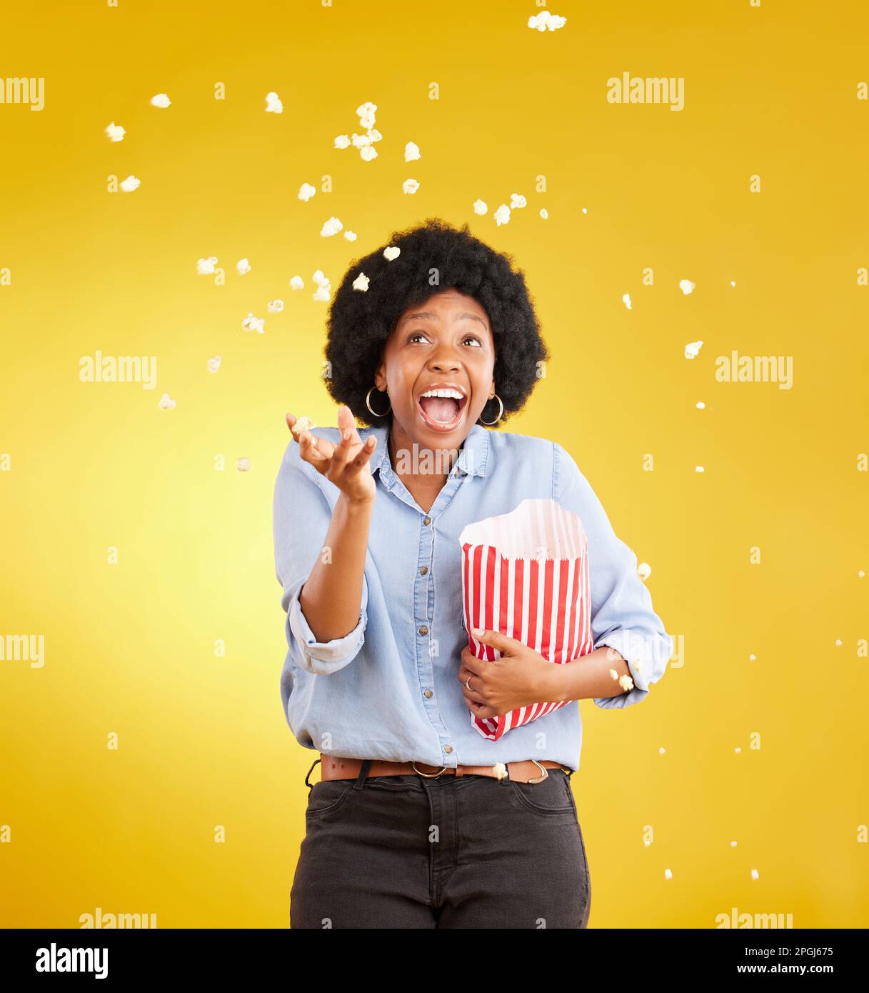 Happy throwing and popcorn with black woman in studio for movie