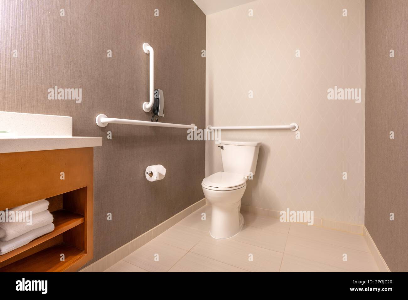 Wheelchair accessible hotel bathroom shower with tile floor and walls