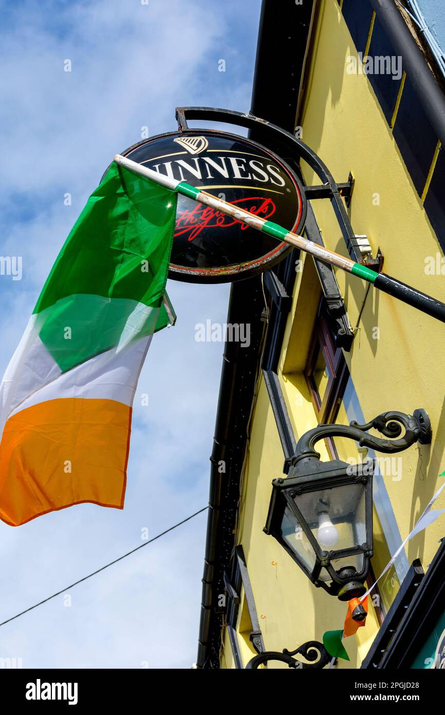 Irish tricolor national flag and Guinness sign outside a bar in County Donegal, Ireland Stock Photo