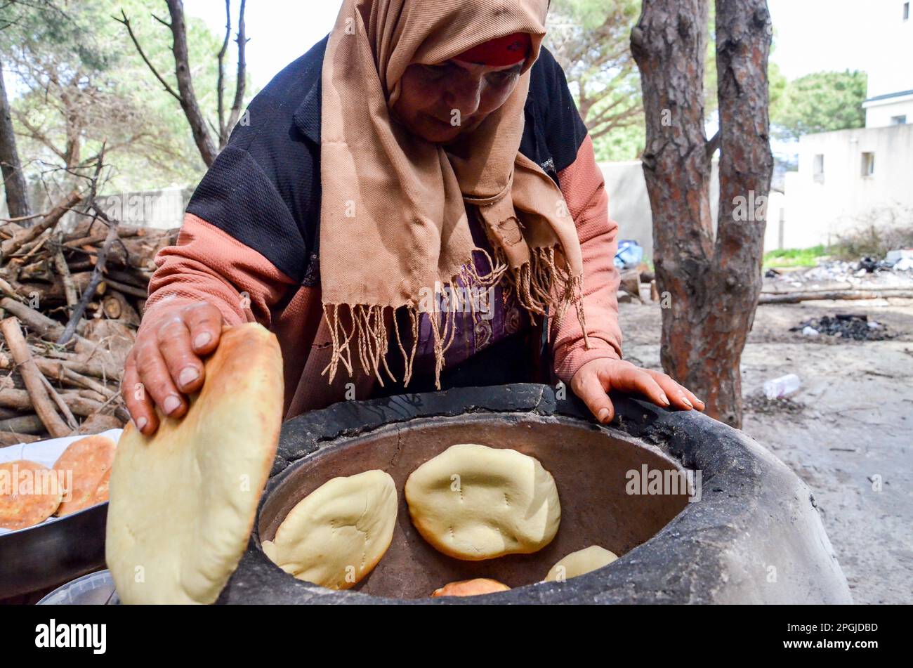 Tunis, Tunisia. 22nd Mar, 2023. Tunis, Tunisia, 22 March 2023. A Tunisian woman bakes the Tabouna bread in a traditional clay oven, before selling it in a market in Tunis. Tabouna is an ancient Tunisian bread made with wheat, semolina, or barley flour and cooked on the walls of a traditional terracotta oven. Tabouna is particularly popular during the Muslim holy month of Ramadan (Credit Image: © Hasan Mrad/IMAGESLIVE via ZUMA Press Wire) EDITORIAL USAGE ONLY! Not for Commercial USAGE! Stock Photo