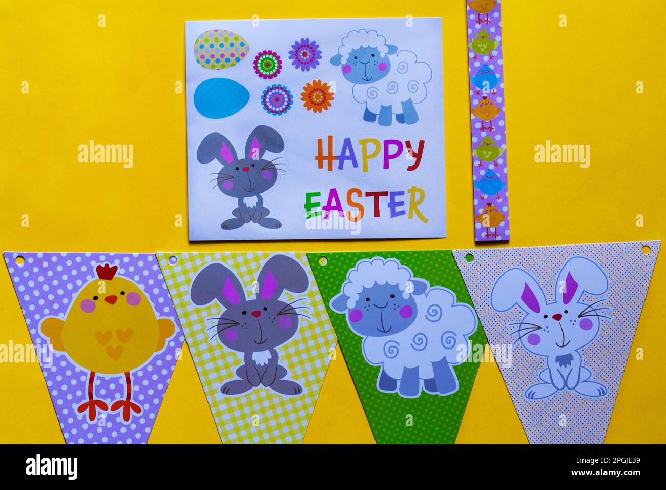 Happy Easter decorations, bunting and stickers on yellow background Stock Photo