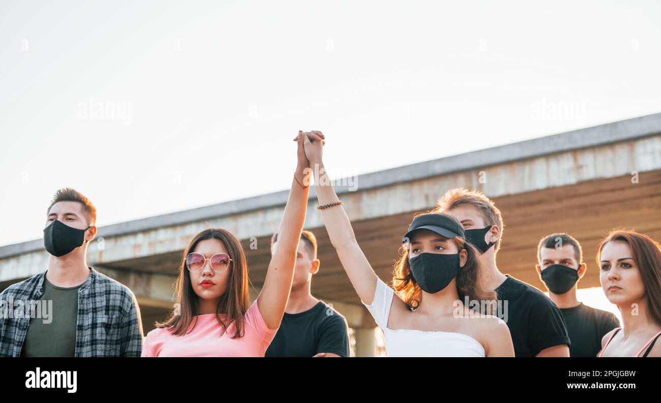 Fists rased high up. Group of protesting young people that standing ...