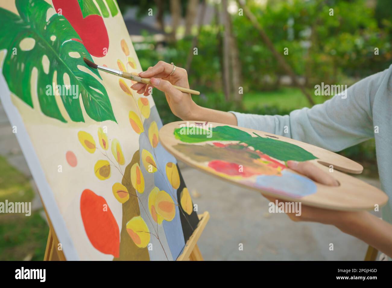 Outdoor activity concept, Female artist holds color palette and brush ...