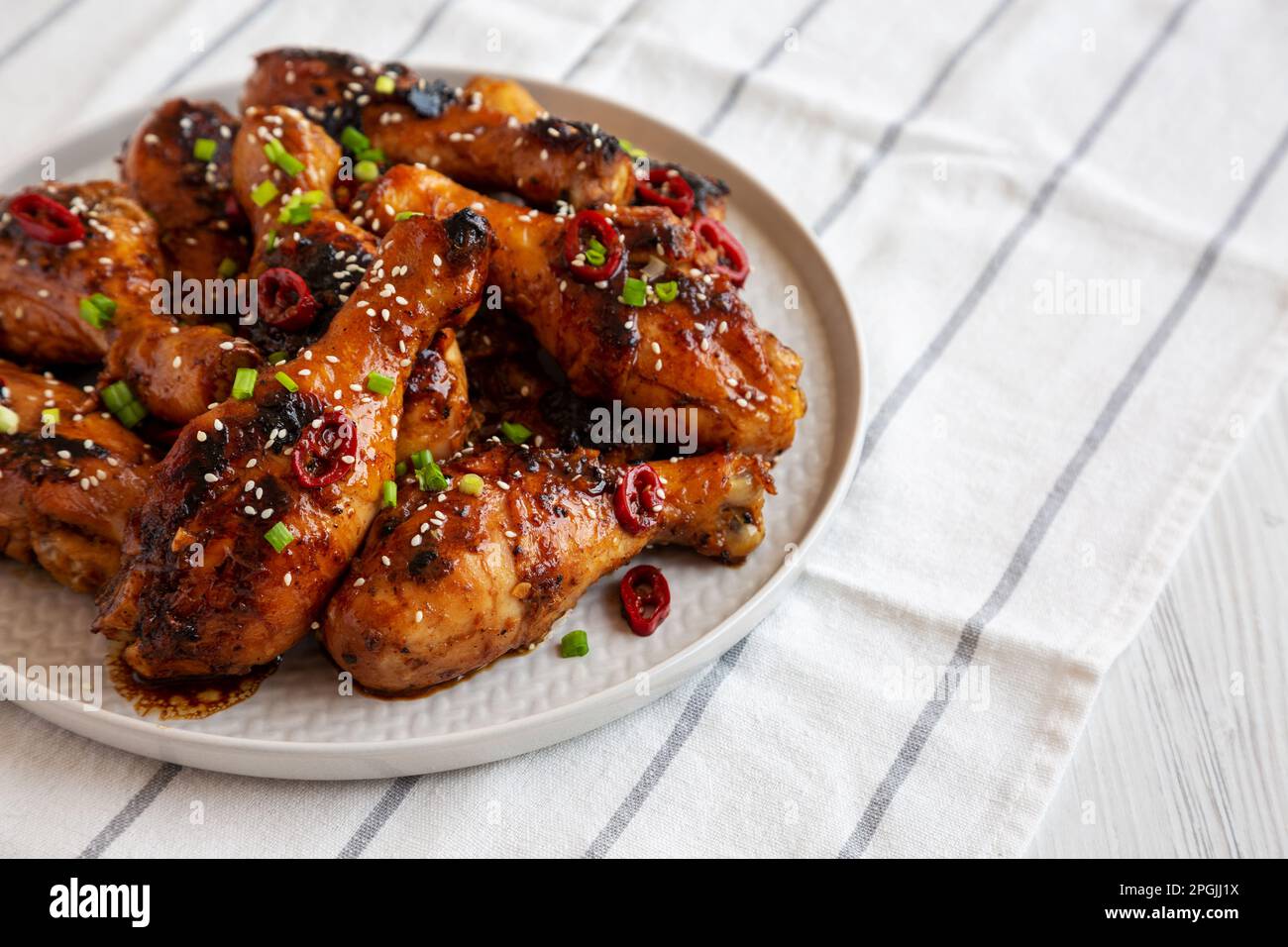Homemade Easy Sticky Chicken Drumsticks on a Plate, side view Stock