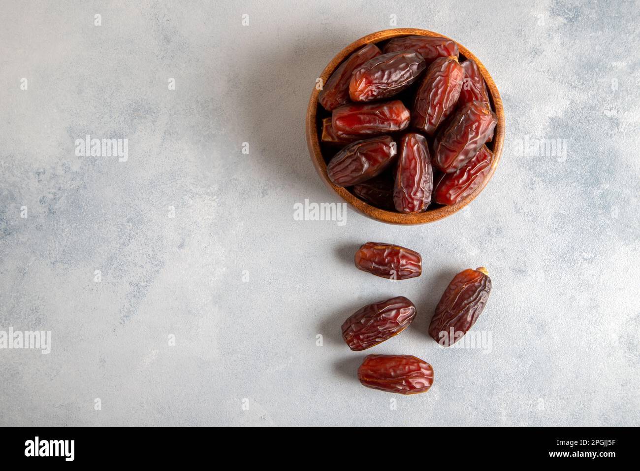 Date fruits in wooden bowl,on bright background Stock Photo