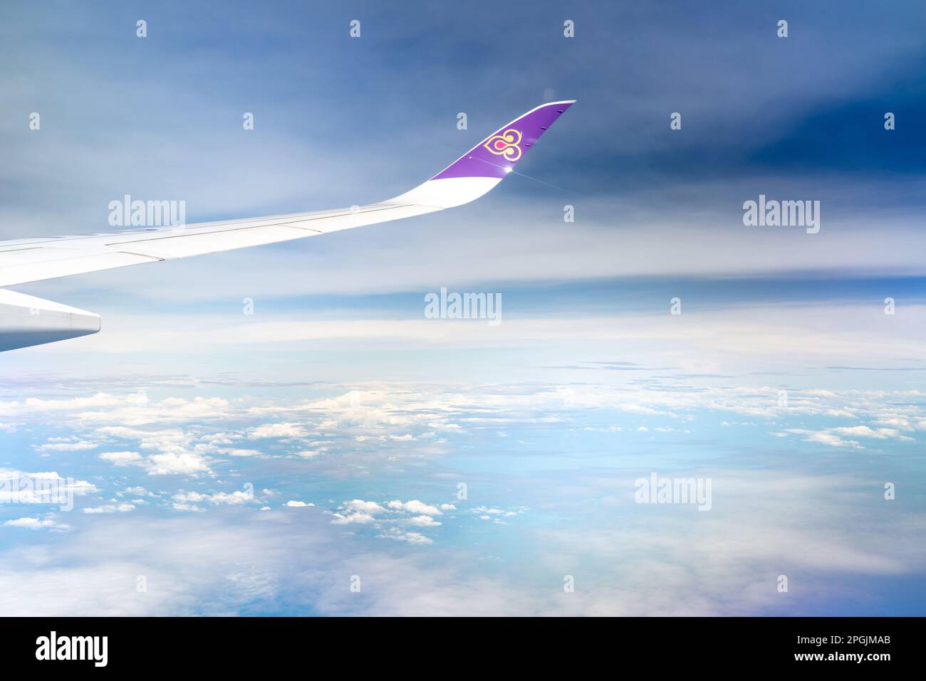 BANGKOK, THAILAND-OCTOBER 19, 2019 : Plane wing of Thai Airways Airlines. Passenger plane. Wing of plane over white fluffy clouds. Airplane flying on Stock Photo