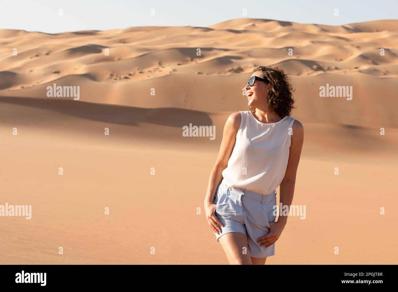 Beautiful young woman posing on the dunes in the desert Stock Photo - Alamy