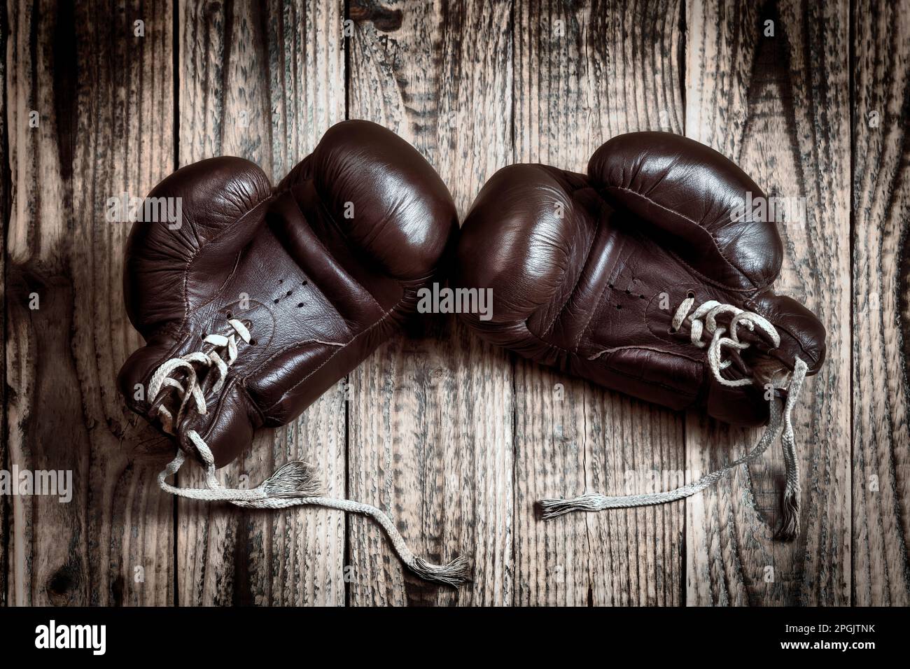 old boxing gloves on wooden background Stock Photo