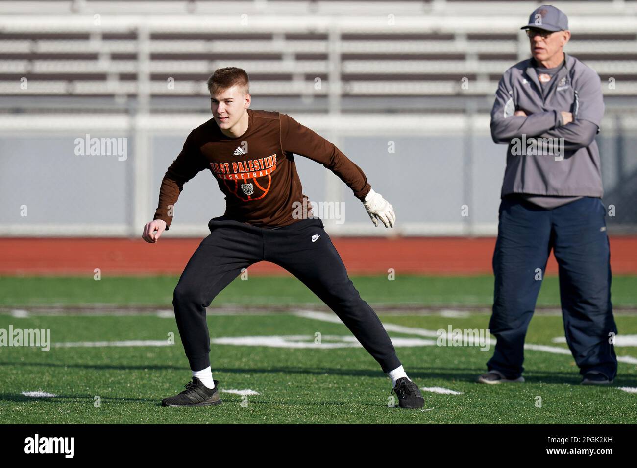 East Palestine High School senior Owen Elliott takes part in baserunning drills next to head