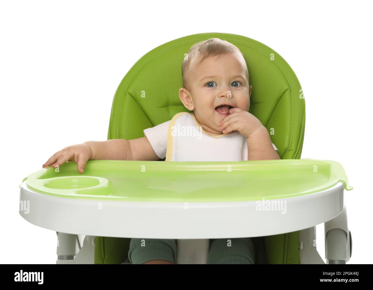 Cute little baby wearing bib in highchair on white background Stock