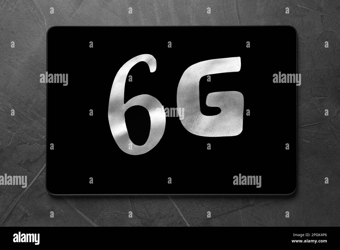 6G technology, Internet concept. Number and letter with tablet on grey table, top view Stock Photo