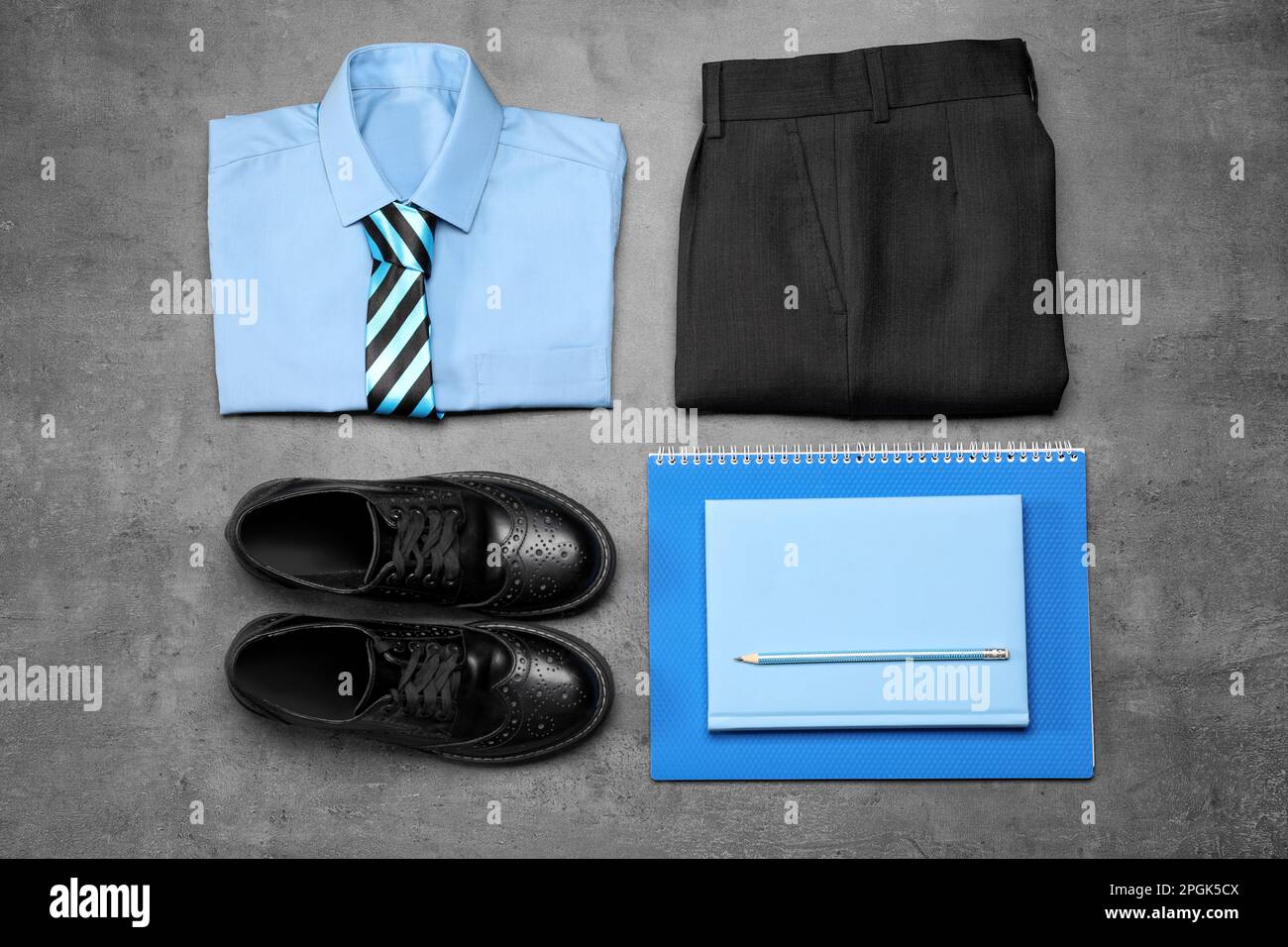 Stylish school uniform for boy and stationery on grey background, flat lay Stock Photo
