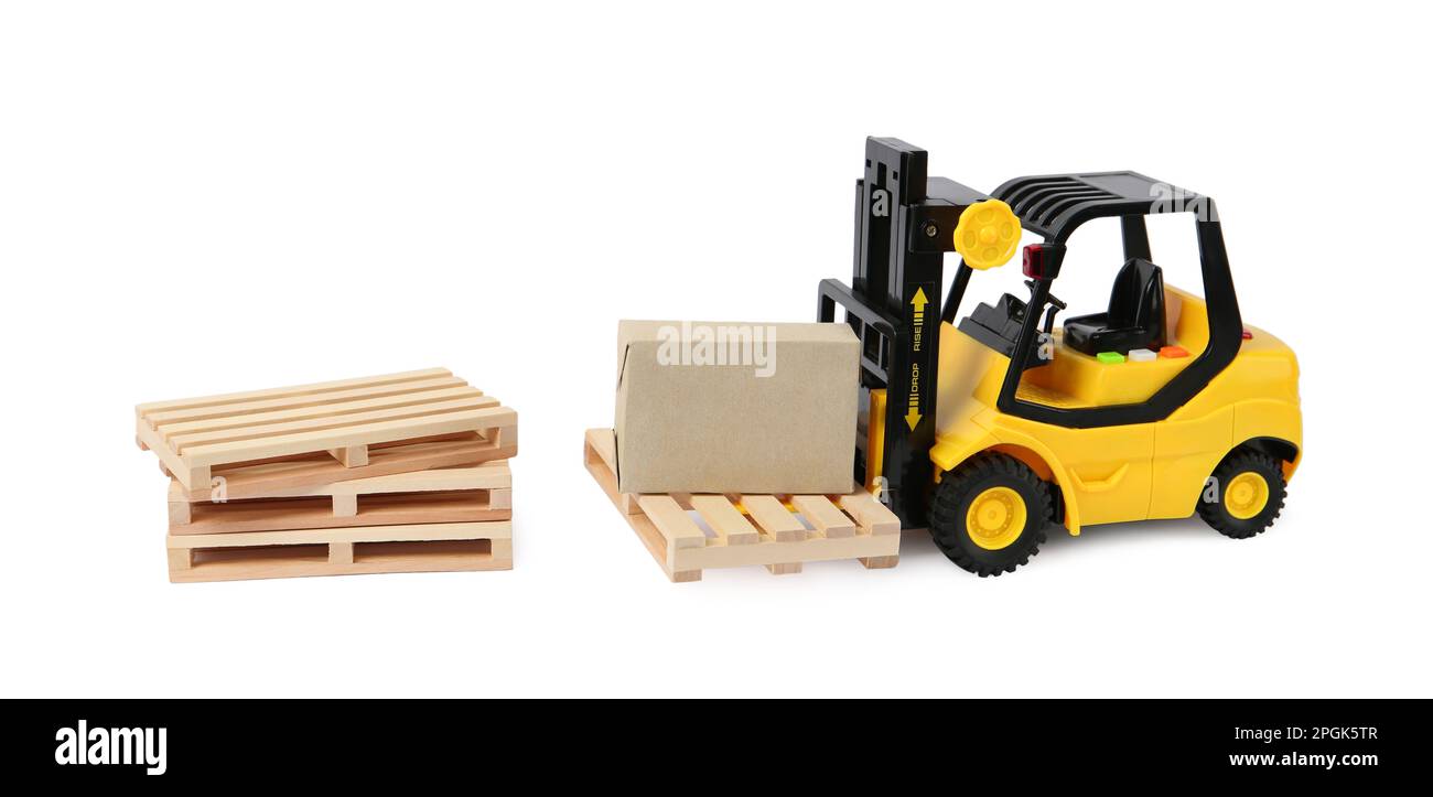 Toy forklift, wooden pallets and box on white background Stock Photo