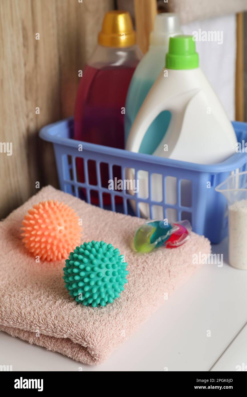 Dryer balls, detergents and clean towel on washing machine Stock Photo