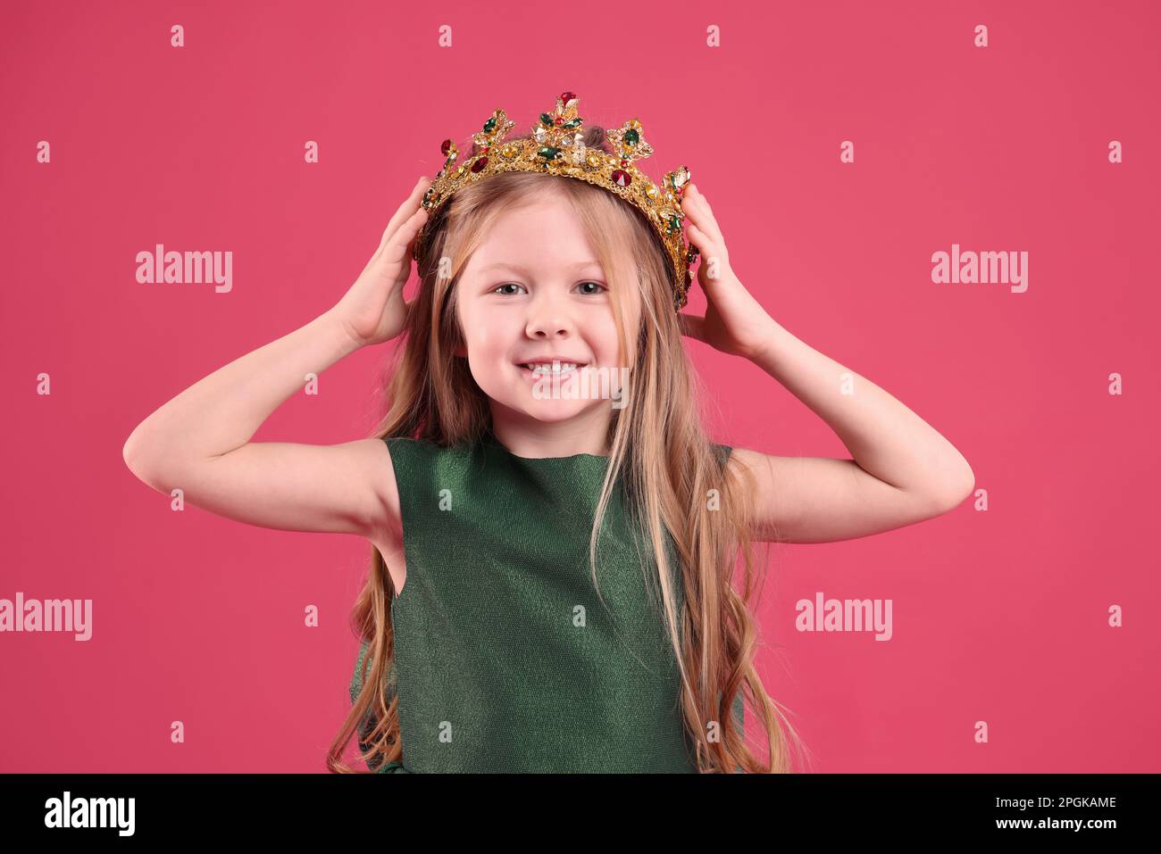 Cute girl in golden crown with gems on pink background. Little princess ...