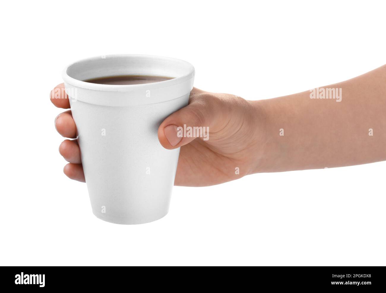 Styrofoam coffee cup with plastic spoon and used creamer container in  foreground and human elbows on table in background. Stock Photo