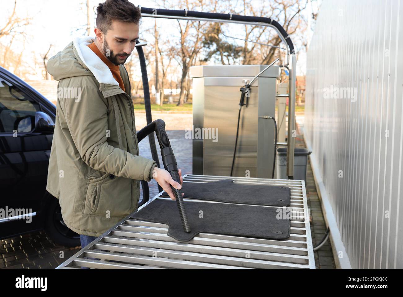 Man cleaning auto carpets with vacuum cleaner at selfservice car wash Stock Photo Alamy