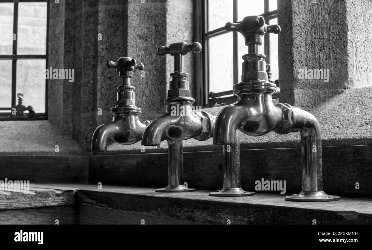 Brass vintage sink taps at Castle Dropo, Drewsteignton, Devon, England, UK Stock Photo