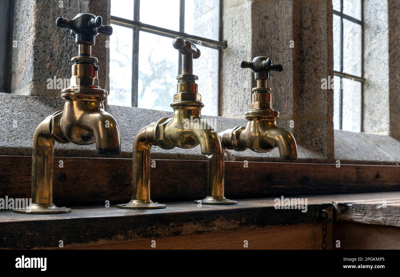 Brass vintage sink taps at Castle Dropo, Drewsteignton, Devon, England, UK Stock Photo